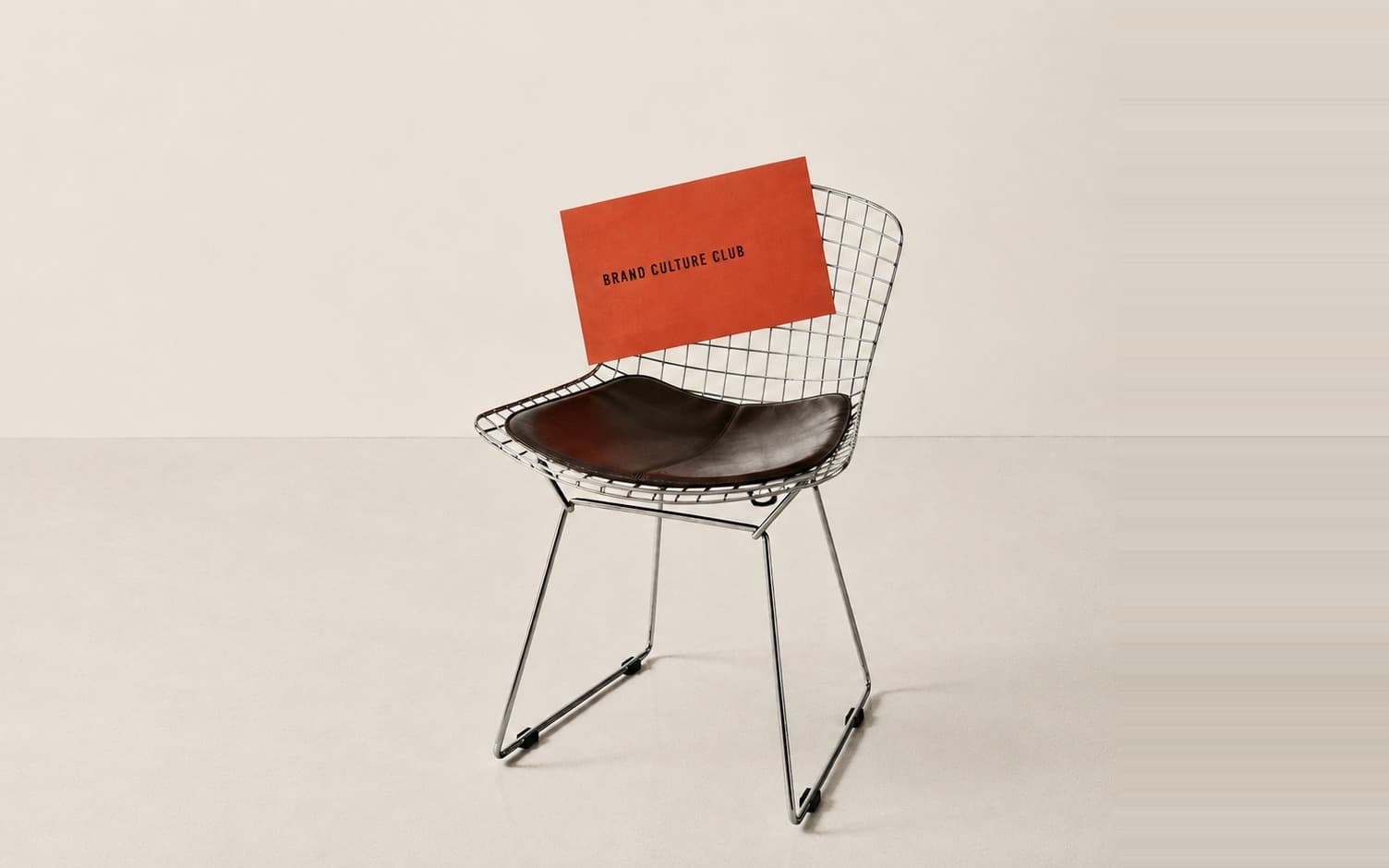 Brand Culture Club business card resting on a wire chair