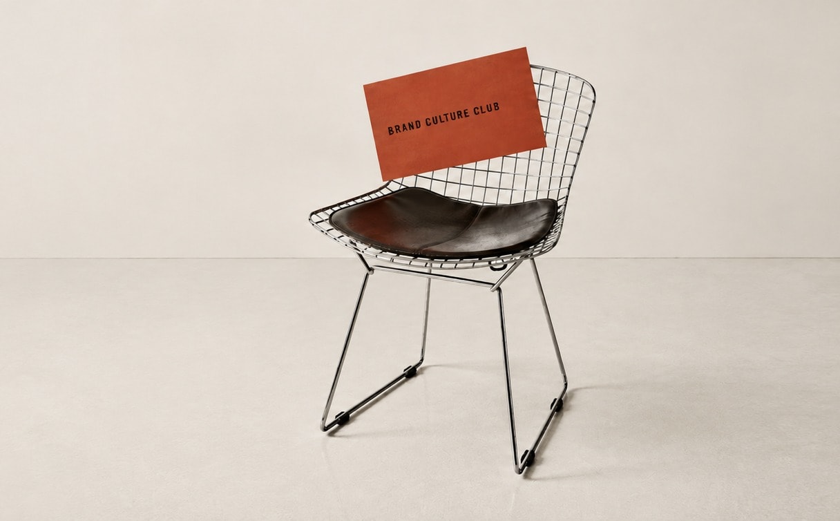 Brand Culture Club business card resting on a wire chair